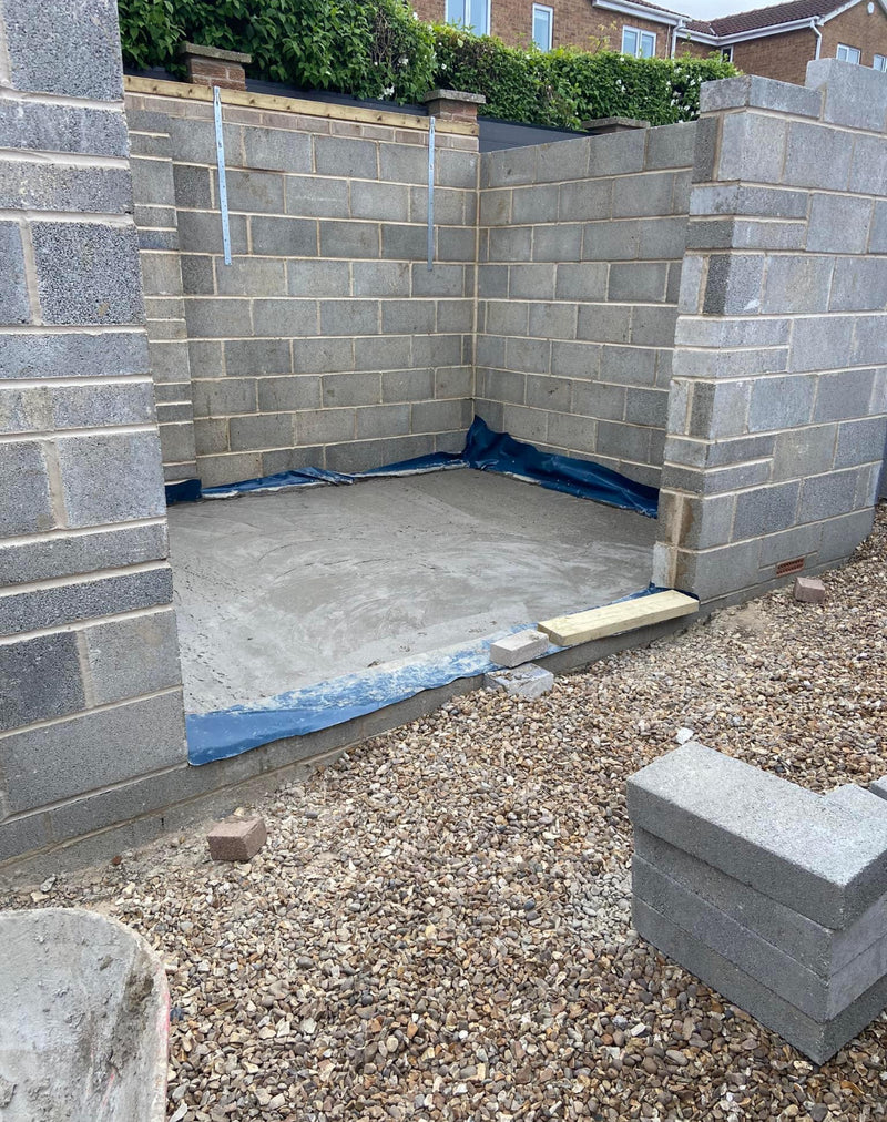 A solid foundation and structural blockwork for a new garage or outbuilding, featuring a poured concrete slab and damp proof membrane (DPM).