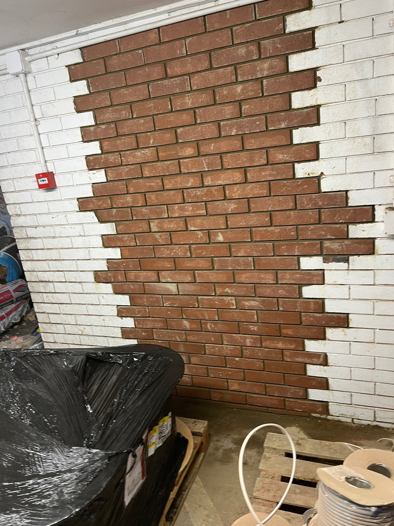 High-quality internal brickwork infill showing perfectly staggered bonding and clean mortar joints to match an existing white-washed wall.