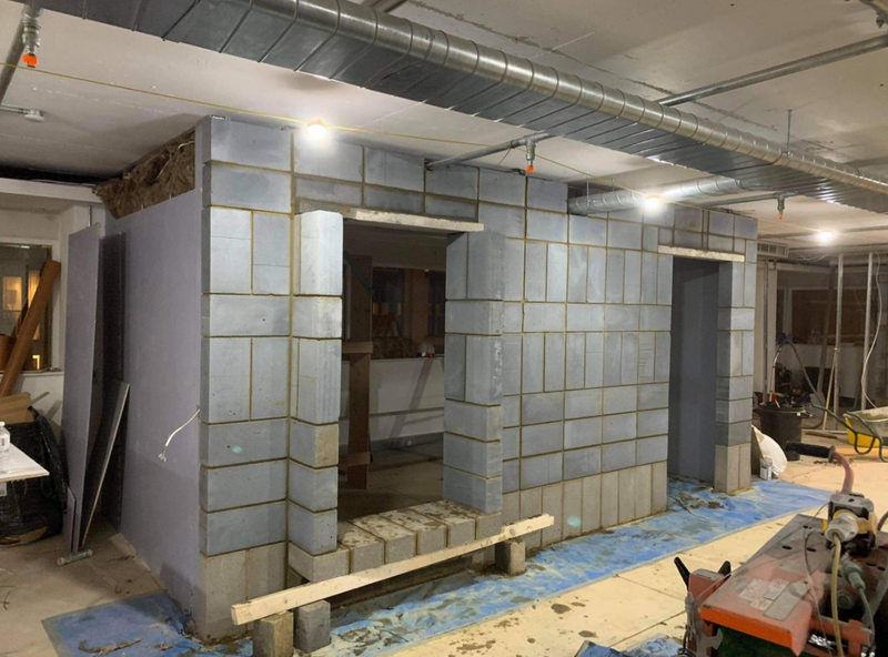 Professional internal masonry work featuring precisely laid cinder block walls for a commercial or large-scale residential partition.