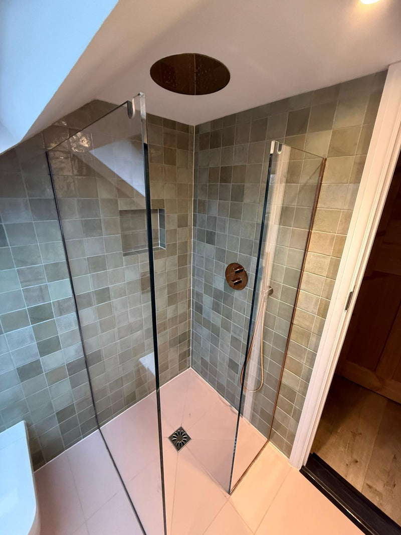 Luxury walk-in shower featuring multi-tonal zellige wall tiles, a recessed tiled niche, and a bespoke wet room floor with brushed bronze fixtures.