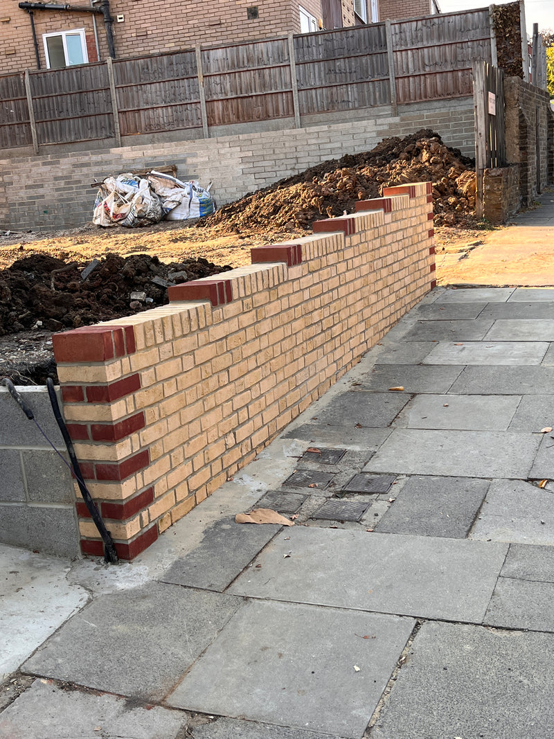 Close-up of a red brick wall undergoing professional repointing. The image shows fresh mortar being applied to joints to restore structural integrity and enhance the appearance of a residential building in London.