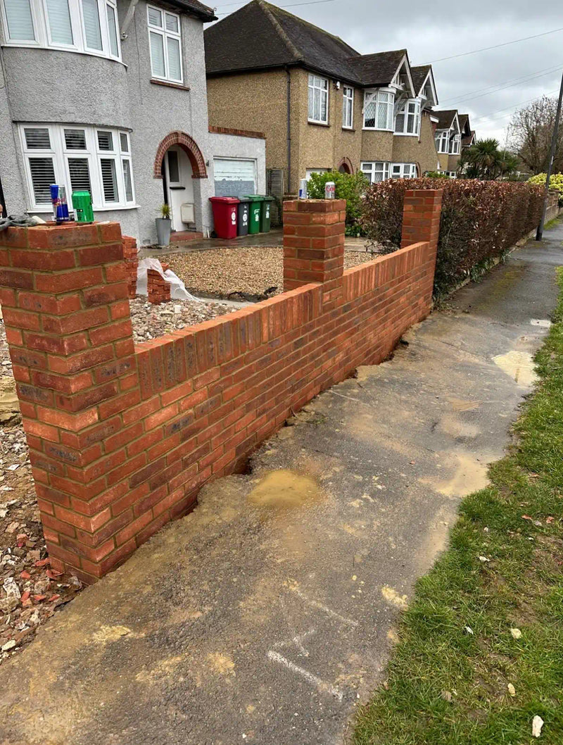 Newly built red brick boundary wall with matching pier pillars and gravel driveway in a London front garden, constructed by Brobrick Construction Ltd.