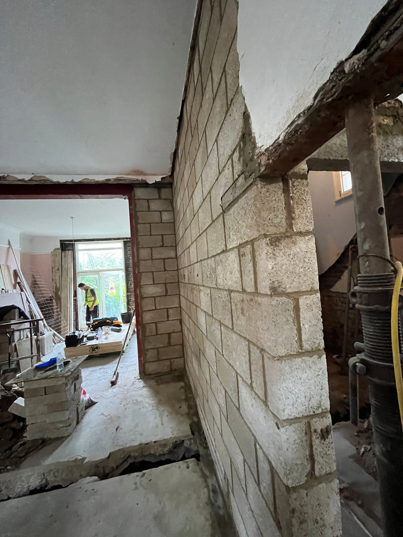 Under construction or renovation interior with exposed brick walls and ceiling.