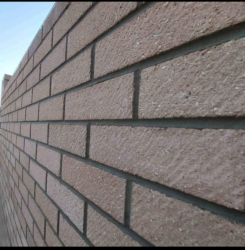 Internal view of a home extension under construction, showing a large structural opening with clean blockwork and a red brick exterior cavity wall.