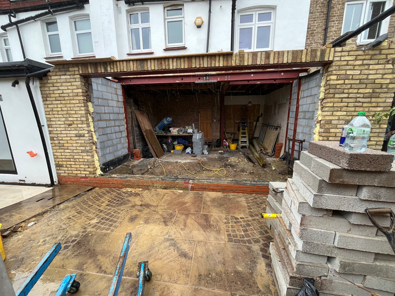 A wide-scale residential rear extension showing the structural steel RSJ beam installation, internal blockwork, and brickwork integration on a period property renovation.